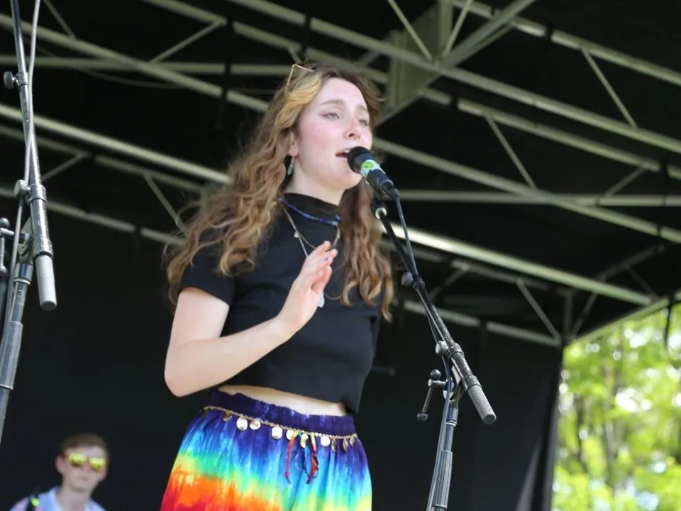 Dakota Allison singing on stage at an outdoor festival